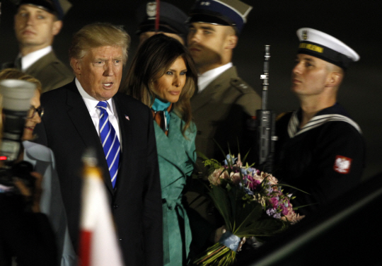 도널드 트럼프(왼쪽) 미국 대통령이 5일(현지시간) 부인 멜라니아 여사와 함께 주요20개국(G20) 정상회의 참석에 앞서 첫 방문지인 폴란드에 도착해 다소 굳은 표정으로 전용기에서 내리고 있다. /바르샤바=AP연합뉴스