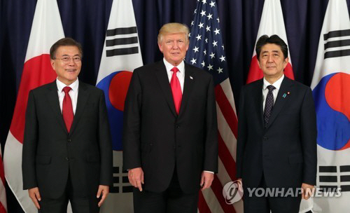 문재인 대통령(왼쪽)과 도널드 트럼프 미국 대통령, 아베 신조 일본 총리가 6일 오후(현지시간) 한미일 정상만찬에서 기념촬영을 하고 있다. /연합뉴스