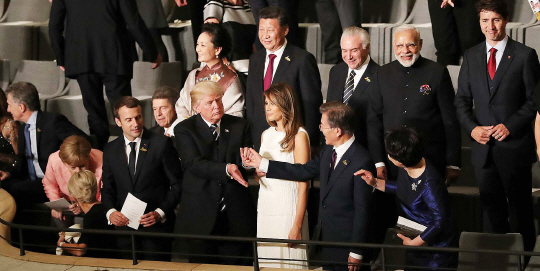 도널드 트럼프 미국 대통령이 7일(현지시간) 독일 함부르크에서 열린 주요20개국(G20) 정상회의 문화공연에서 문재인 대통령의 손을 잡고 보란 듯이 친밀감을 과시하자 시진핑(뒷줄 왼쪽 두번째) 중국 국가주석이 이 모습을 애써 외면하고 있다. 트럼프 대통령의 이 같은 돌발행동은 시 주석에게 한미동맹이 보다 굳건해졌음을 보여주기 위한 의도에서 나온 것으로 분석된다. /연합뉴스
