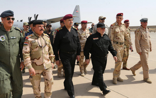 하이데르 알아바디(왼쪽 네번째) 이라크 총리가 9일(현지시간) 모술에 도착해 군 관계자들과 걷고 있다. 알아바디 총리는 이날 이슬람 극단주의 무장단체 ‘이슬람국가(IS)’로부터의 모술 완전 해방을 선언했다.    /모술=AFP연합뉴스