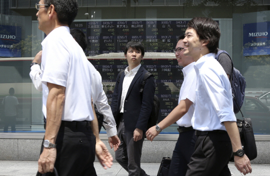 지난 7일(현지시간) 일본 도쿄의 직장인들이 한 증권사 앞을 걸어가고 있다. /도쿄=AP연합뉴스