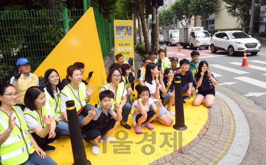 한국공항공사가 12일 오후 서울 양천구 강서초등학교 앞 횡단보도에서 'KAC 포티 옐로카펫 사업'을 벌여 공사 임직원들과 자원봉사자, 어린이들이 함께 미끄럼 방지 패드를 부착하고 있다. 한국공항공사는 올해 강서초등학교를 시작으로 강서, 양천, 구로, 경기 부천시, 김포시, 인천시 계양구 소재 초등학교 15곳에 횡단보도에서 자주 일어나는 어린이 교통사고를 줄여주는 '옐로카펫'을 설치를 할 계획이다./이호재기자.