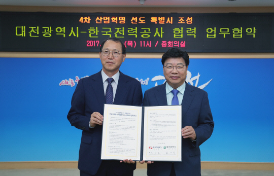 권선택(사진 오른쪽) 대전시장과 김시호(〃왼쪽) 한국전력 부사장이 에너지산업 중심 4차 산업혁명 특별시 조성을 위한 업무협약을 체결하고 있다. 사진제공=대전시