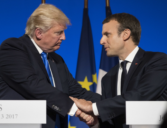 13일(현지시간) 에마뉘엘 마크롱(오른쪽) 프랑스 대통령과 도널드 트럼프(왼쪽) 미국 대통령이 프랑스 파리 엘리제궁에서 공동 기자회견을 마친 뒤 악수하고 있다. /파리=AP연합뉴스