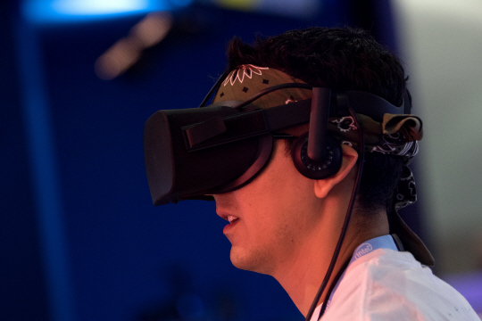지난달 14일(현지시간) 미국 로스앤젤러스(LA) 전자오락박람회에 방문한 한 참석자가 오큘러스 가상현실(VR) 헤드셋을 체험하고 있다./LA=블룸버그통신