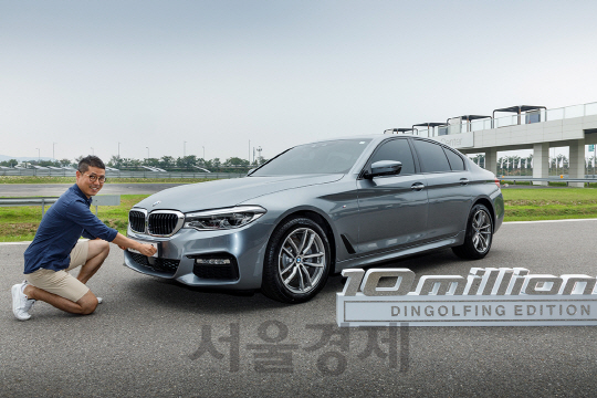 21일 영종도 BMW 드라이빙 센터에서 열린 뉴 5시리즈 딩골핑 에디션 차량전달식에서 경매 낙찰자가 차량에 번호판을 달고 있다./사진제공=BMW그룹코리아