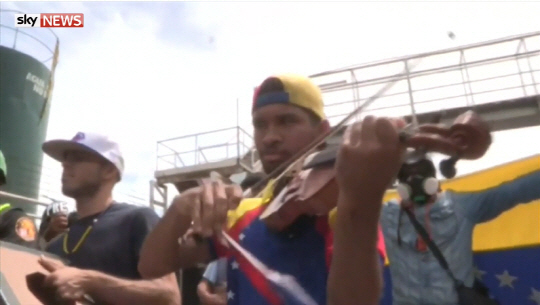 우일리 아르테아가는 돌과 화염병이 날아다니는 시위 현장에서 베네수엘라 전통음악인 ‘알마야네라’를 바이올린으로 연주해 유명해졌다.  /영국 스카이뉴스 캡처