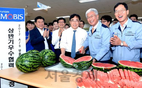 조성진(오른쪽 두번째) 현대모비스 통합구매담당 이사와 허재명(〃세번째) 대원산업 대표가 24일 경기도 안산 대원산업에서 함께 수박을 자르며 상생 협력을 다짐하고 있다./사진제공=현대모비스