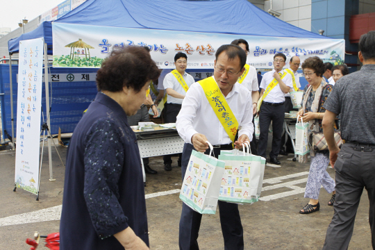 여영현 경북농협 본부장에서 25일 동대구역에서 시민들에게 ‘농촌에서 휴가보내기’를 당부하며 기념품을 나눠주고 있다.