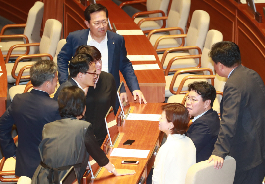 22일 오전 열린 국회 본회의에서 정족수 부족으로 투표가 종료되지 않자 더불어민주당 의원들이 본회의장에 남아있던 자유한국당 장제원 의원과 논의하고 있다. /연합뉴스