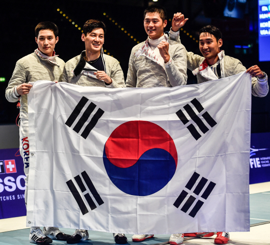 한국 남자 사브르 대표팀이 25일 라이프치히 세계선수권에서 우승한 뒤 태극기를 펼쳐 보이고 있다. 김준호(왼쪽부터)·김정환·오상욱·구본길. /라이프치히=EPA연합뉴스