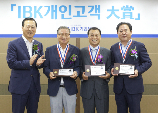 김도진 기업은행장(왼쪽)이 25일 서울 을지로 본점에서 열린 ‘2017 IBK개인고객 대상’ 시상식에서 홍순탁(사진 두번째), 황석성(〃 세번째), 안혁(〃 네번째) 고객에게 감사패를 전달하고 있다. /사진제공=IBK기업은행