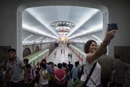평양을 방문한 한 여성 관광객이 지하철역 내부를 배경으로 사진촬영을 하고 있다. /평양=AFP연합뉴스