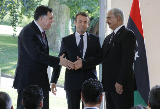 에마뉘엘 마크롱 프랑스 대통령의 중재로 리비아 통합정부의 파예즈 사라지 총리(왼쪽)와 리비아 동부지역 대부분을 통치하고 있는 칼리파 하프타르 군사령관(오른쪽)이 휴전에 합의하고 있다./AP연합뉴스