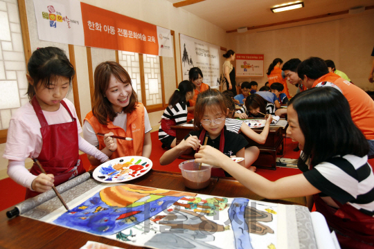 한화그룹이 26일 서울 종로 무계원에서 진행한 ‘한화예술더하기’ 활동에서 참여한 초등학생들과 한화 임직원 봉사자들이 각자의 ‘몽유도원도’를 그리고 있다. /사진제공=한화그룹