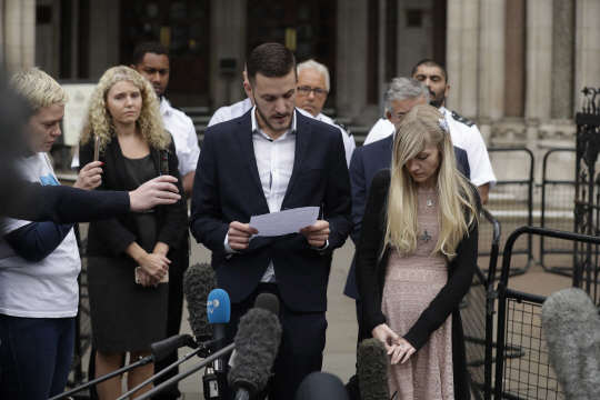 영국 희소병 환아 찰리 가드의 부모인 크리스 가드(가운데)와 코니 예이츠(오른쪽 첫번째)가 지난 24일(현지시간) 영국 런던 고등법원 앞에서 기자회견을 하는 모습. /런던=AP연합뉴스