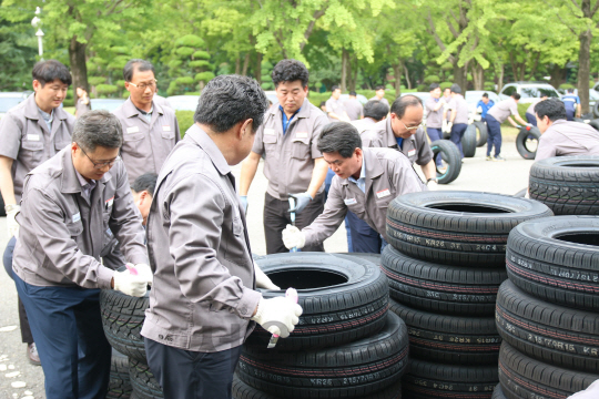 이한섭(둘째 줄 오른쪽 첫 번째) 금호타이어 대표이사와 임직원 100여명이 28일 광주공장에서 타이어 절단식을 하고 있다. /사진제공=금호타이어