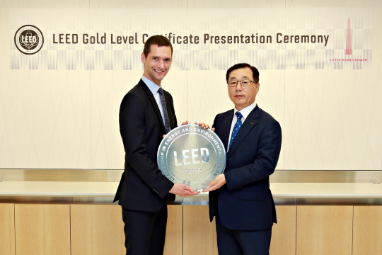 박현철(오른쪽) 롯데물산 대표가 미국그린빌딩협의회(USGBC)피터 탬플레튼 수석 부의장으로부터 리드(LEED) 골드 등급 인증 패를 받고 있다./사진제공=롯데물산