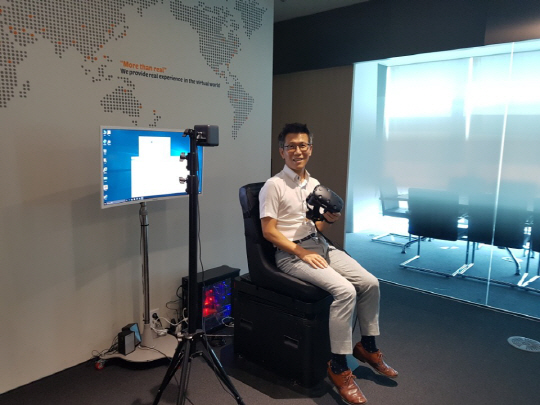 조준희 이노시뮬레이션 대표가 VR모션키트에 앉아 제품을 소개하고 있다./한동훈기자