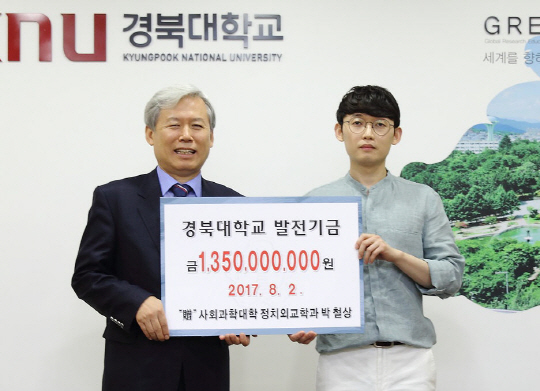 ‘대학생 기부왕’ 박철상씨가 앞으로 5년간 모교인 경북대에 장학금 13억5,000만원을 내놓기로 하는 기부약정식을 2일 김상동 총장과 갖고 있다. /사진제공=경북대