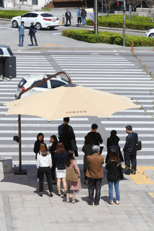 서울 시민들이 서초구의 접이식 그늘막 아래서 폭염을 피하고 있다. /사진제공=서초구청