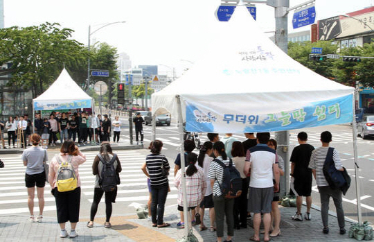 서울 시민들이 동작구의 천막형 그늘막 아래서 폭염을 피하고 있다. /사진제공=동작구청