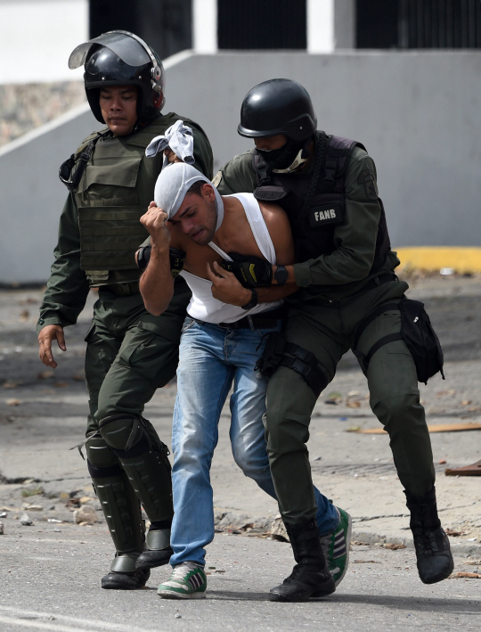 베네수엘라의 수도 카라카스에서 27일(현지시간) 국경수비대에 의해 반정부 활동가가 체포되고 있다./카라카스=AFP연합뉴스