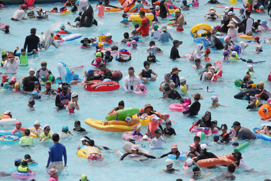 서울 대부분의 지역 낮 최고기온이 35도를 넘은 5일 오후 서울 한강망원수영장을 찾은 시민들이 물놀이를 즐기고 있다. /연합뉴스