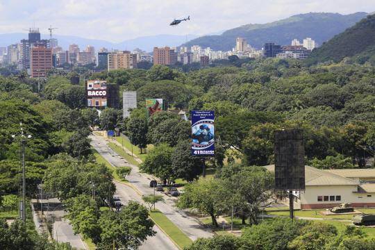 6일(현지시간) 총격전이 발생한 베네수엘라 발렌시아시의 군 기지 상공을 한 헬리콥터가 비행하고 있다. /발렌시아=AP연합뉴스