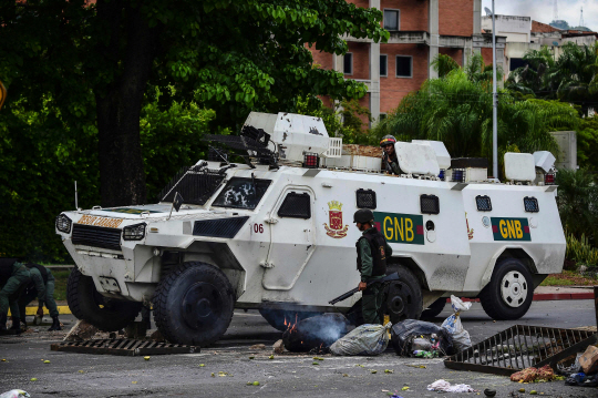 베네수엘라 국경수비대 차량이 6일(현지시간) 발렌시아시에서 반정부시위대의 바리케이드를 뚫고 지나가고 있다. /발렌시아=AFP연합뉴스
