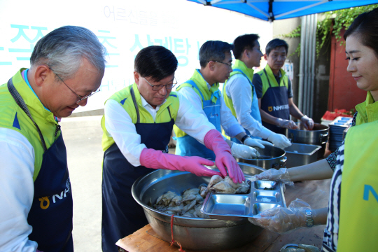 김원규(왼쪽 두번째) NH투자증권 사장이 서울 영등포 쪽방촌을 찾아 자활 노숙인과 거주민을 위해 삼계탕을 배식하고 있다.  /사진제공=NH투자증권