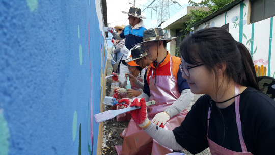 11일 오후 SK울산공장 구성원들이 공장 인근 마을을 찾아가 벽화 그리기 자원봉사 활동을 하고 있다. /사진제공=SK울산Complex