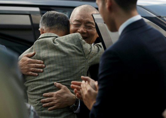 북한에 억류됐다 31개월 만에 풀려난 한국계 캐나다인 임현수(가운데) 목사가 13일(현지시간) 예배 참석을 위해 캐나다 온타리오주 미시소거의 큰빛교회에 도착한 뒤 신자들과 포옹하고 있다. /미시소거=AFP연합뉴스