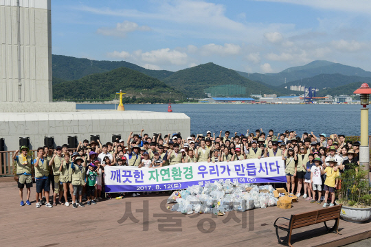 볼보건설기계코리아 임직원과 협력사 직원 200여명이 12일 창원시 귀산 해변 일대에서 환경정화 활동을 마치고 화이팅을 외치고 있다./사진제공=볼보건설기계코리아