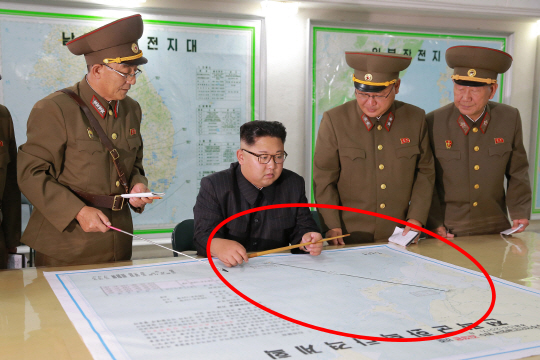 전략군사령부 방문한 김정은 노동당 위원장. 앞에 놓인 ‘전략군화력타격계획’ 지도에 알 수 없는 표시가 돼 있다. / 연합뉴스