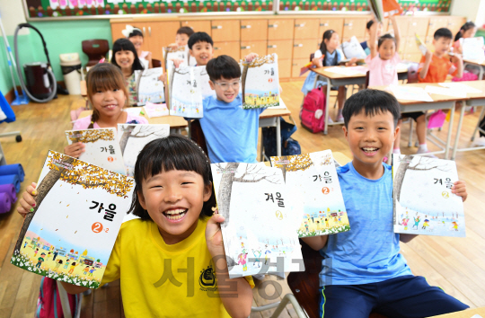 16일 오전 서울 노원구 신계초등학교에서 개학을 맞은 아이들이 2학기 교과서를 들고 밝게 웃고 있다./송은석기자songthomas@sedaily.com