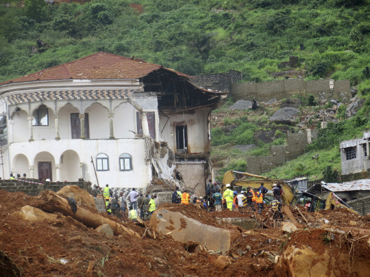 Volunteers search for bodies from the scene of heavy flooding and mudslides in Regent, just outside of Sierra Leone‘s capital Freetown, Tuesday, Aug. 15 , 2017. Survivors of deadly mudslides in Sierra Leone’s capital are vividly describing the disaster as President Ernest Bai Koroma says the nation is in a “state of grief.” (AP Photo/ Manika Kamara)      <저작권자(c) 연합뉴스, 무단 전재-재배포 금지>