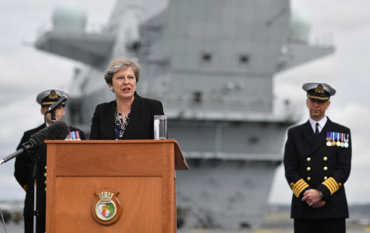 테리사 메이 영국 총리가 16일(현지시간) 모항 포츠머스 해군기지에 입항한 영국의 첨단 새 항공모함 ‘퀸 엘리자베스’ 갑판에서 연설을 하고 있다. /AFP연합뉴스
