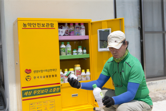 충남 서천군의 한 주민이 자신의 집에 설치된 농약안전보관함에서 농약을 꺼내고 있다. /사진제공=생명보험사회공헌재단