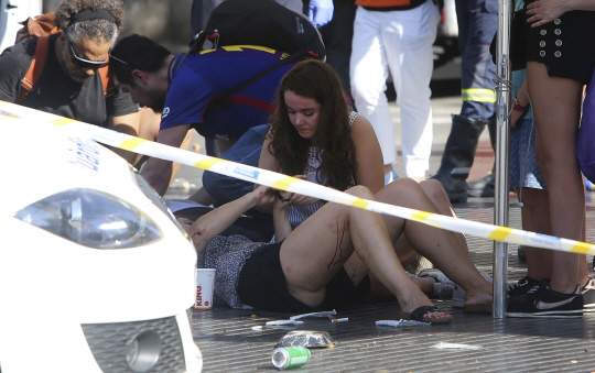 Injured people are treated in Barcelona, Spain, Thursday, Aug. 17, 2017 after a white van jumped the sidewalk in the historic Las Ramblas district, crashing into a summer crowd of residents and tourists and injuring several people, police said. (AP Photo/Oriol Duran)      <저작권자(c) 연합뉴스, 무단 전재-재배포 금지>