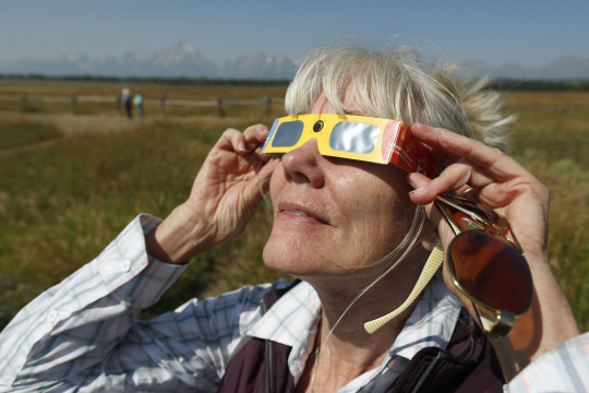 JACKSON, WY - AUGUST 20: Penny Farster-Narlesky of Denver Colorado test her solar eclipse glasses at an roadside information center in Grand Teton National Park on August 20, 2017 outside Jackson, Wyoming. People are flocking to the Jackson and Teton National Park area for the 2017 solar eclipse which will be one of the areas that will experience a 100% eclipse on Monday August 21, 2017.   George Frey/Getty Images/AFP  == FOR NEWSPAPERS, INTERNET, TELCOS & TELEVISION USE ONLY ==      <저