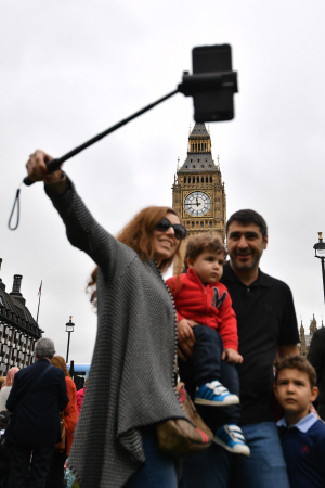 런던 시민들이 마지막 종소리를 울린 빅벤을 기억하고자 가족들과 기념 사진을 촬영하고 있다./런던=AFP연합뉴스