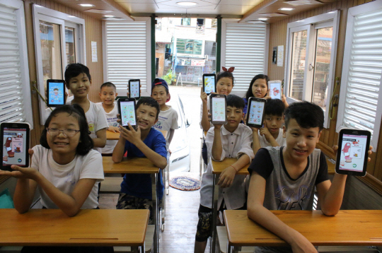 지난 21일 미얀마 양곤의 한 공장을 방문한 ‘삼성 모바일 교육 버스’에서 미얀마 어린이들이 영어, 수학 등 기초 교육을 받으며 즐거워 하고 있다. 삼성전자는 2015년 미얀마에서 ‘삼성 모바일 교육 버스’를 시작했으며, 이달부터 수업 공간에 별도의 주방 공간까지 갖춘 신형 교육 버스와 스마트 TV, 갤럭시 탭을 추가로 지원해 총 3대의 교육 버스를 운영한다고 23일 밝혔다./사진제공=삼성전자