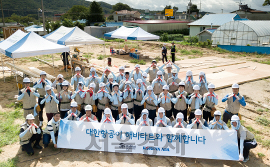 대한항공 소속 스포츠단 선수 및 임직원들이 24일 진행한 해비타트 ‘희망의 집짓기’ 봉사활동 후 함께 모여 손으로 집 모양을 만들며 단체 촬영을 하고 있다./사진제공=대한항공