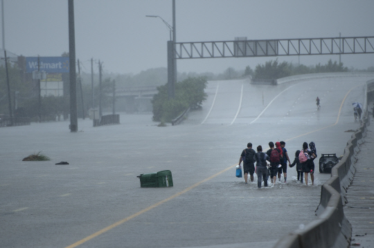 허리케인 하비가 상륙한  텍사스 주  휴스턴에서 27일(현지시간) 이재민들이 강으로 변한 고가도로를 통해 대피하고 있다./휴스턴=AFP연합뉴스