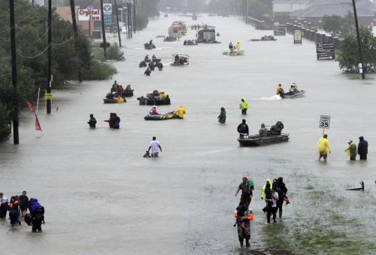 허리케인 ‘하비’가 미국 텍사스주를 강타한 가운데 텍사스주 최대 도시 휴스턴이 28일(현지시간) 물에 잠기자 구조보트들이 주민들을 안전한 곳으로 실어나르고 있다. /휴스턴=AP연합뉴스