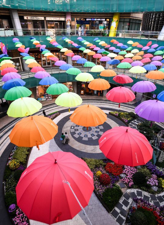 저층 상가 공간의 중앙광장 위쪽에 걸려 있는 무지개색 우산들은 이곳을 더욱 돋보이게 한다. /송은석기자