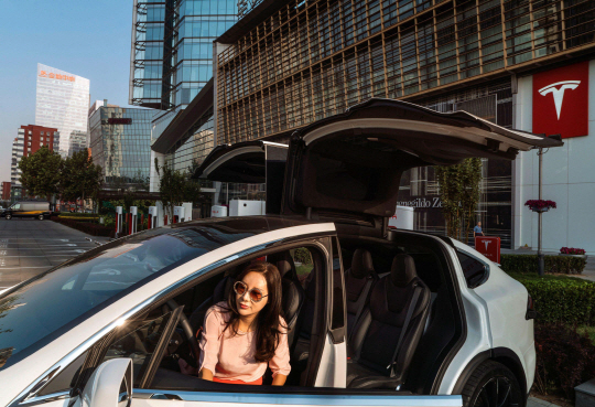 안전 제일 : 베이징의 한 테슬라 전시 매장에서 베네사 주가 자신의 모델 X차량에서 나오고 있다. SUV에 대한 높은 수요와 더 안전하다는 인식이 중국 시장에서 테슬라의 성장을 이끌고 있다.