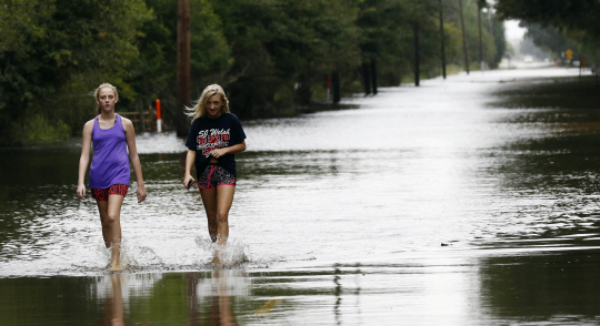 30일(현지시간) 폭우가 내린 루이지애나주 아이오와에서 두 시민이 거리를 걷고 있다. /AP연합뉴스