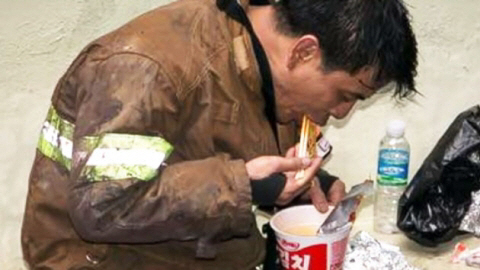 화재진압을 마친 소방관이 한 구석에서 컵라면을 먹고 있는 모습./사진= 부산경찰페이스북